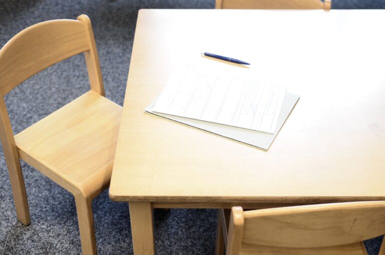 An empty, well-lit primary school classroom featuring modern student desk and educational charts in the Netherlands.