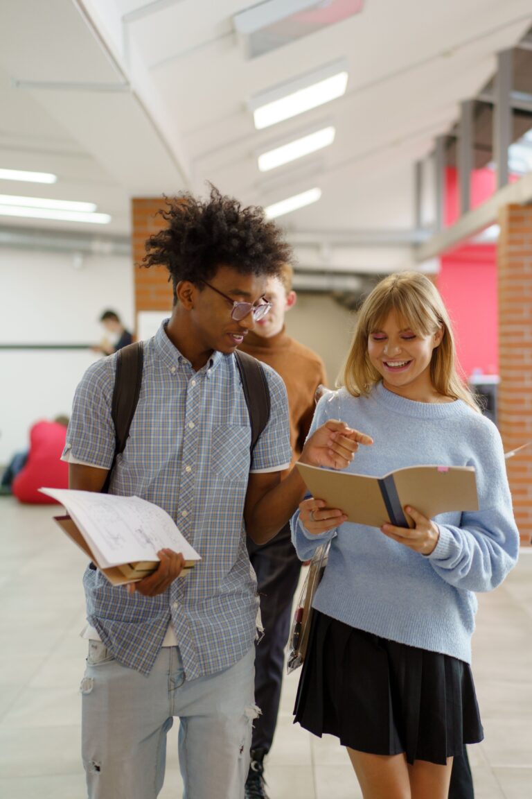 Two secondary school students walking down a modern Dutch school hallway together.