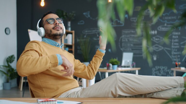 A smiling professional employee working remotely in a bright, modern office environment.