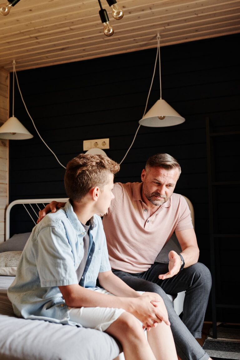 A father having a supportive conversation with his son about choosing a new school.