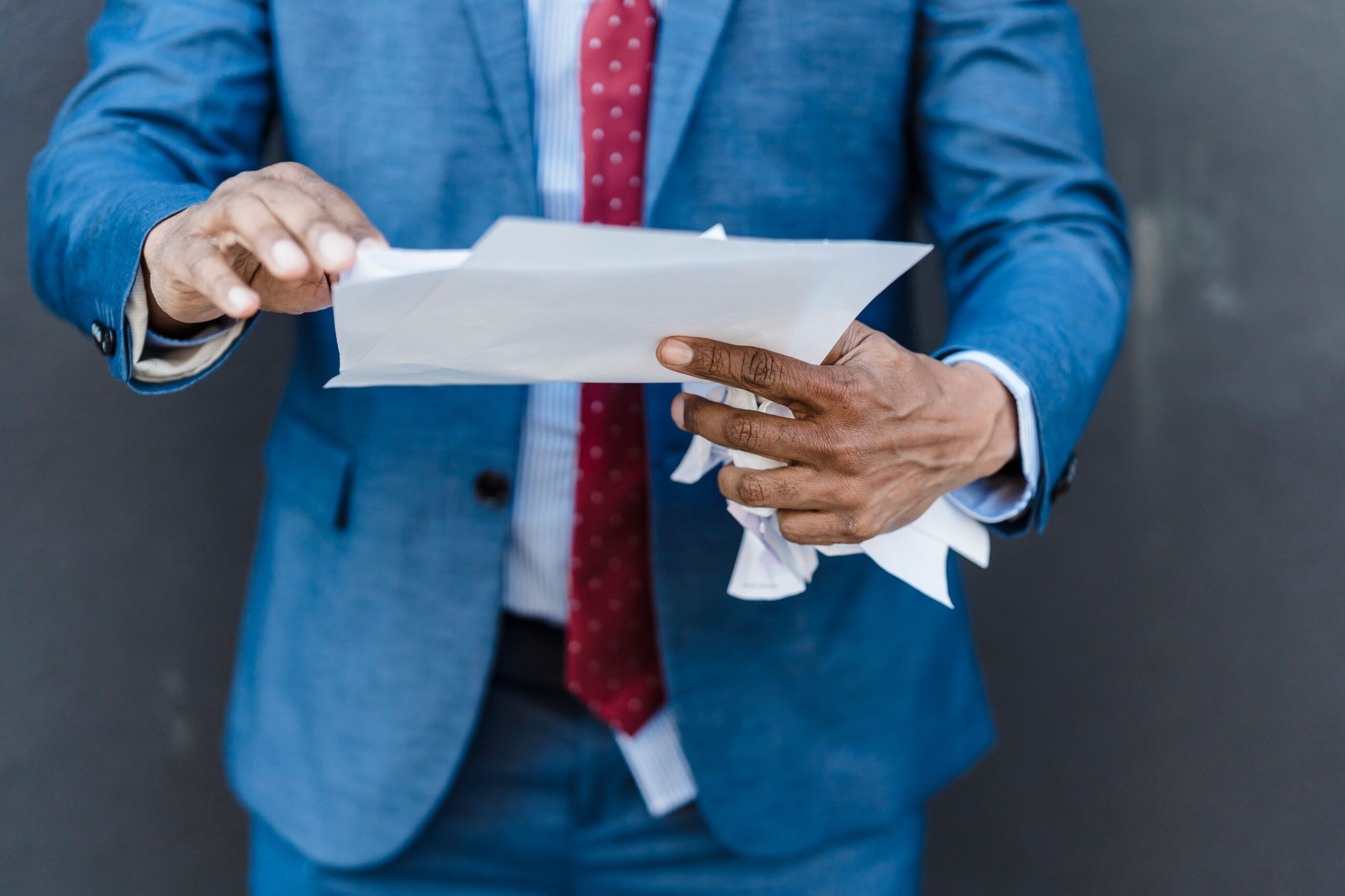 A corporate professional looking concerned while reviewing a document or declined employment contract.