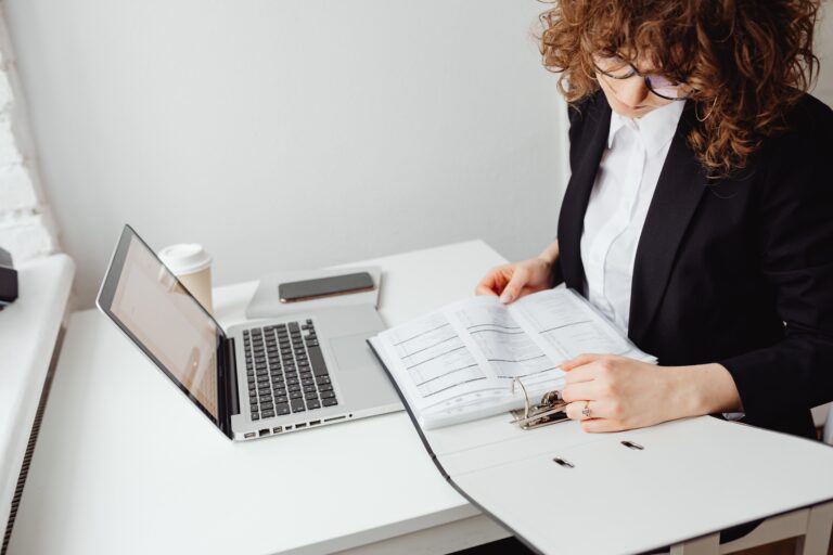 A corporate professional analyzing financial data and reports at a desk.