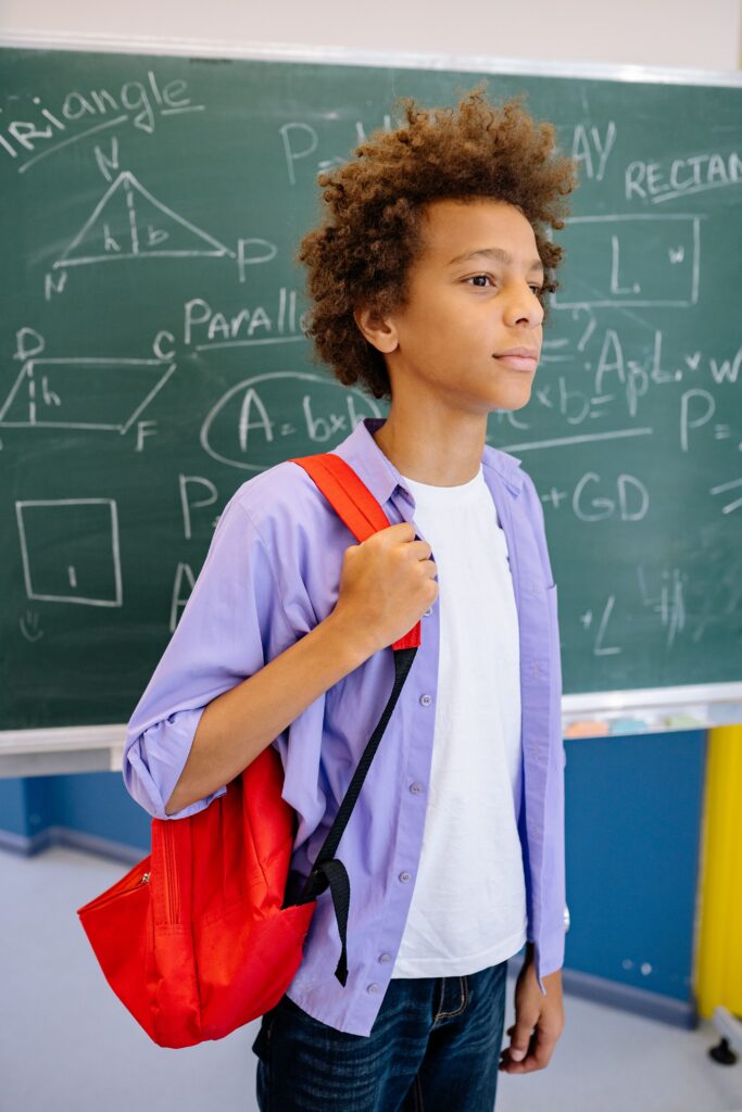 Expat boy with a heavy backpack arriving at a Dutch secondary school for his first year in the brugklas.